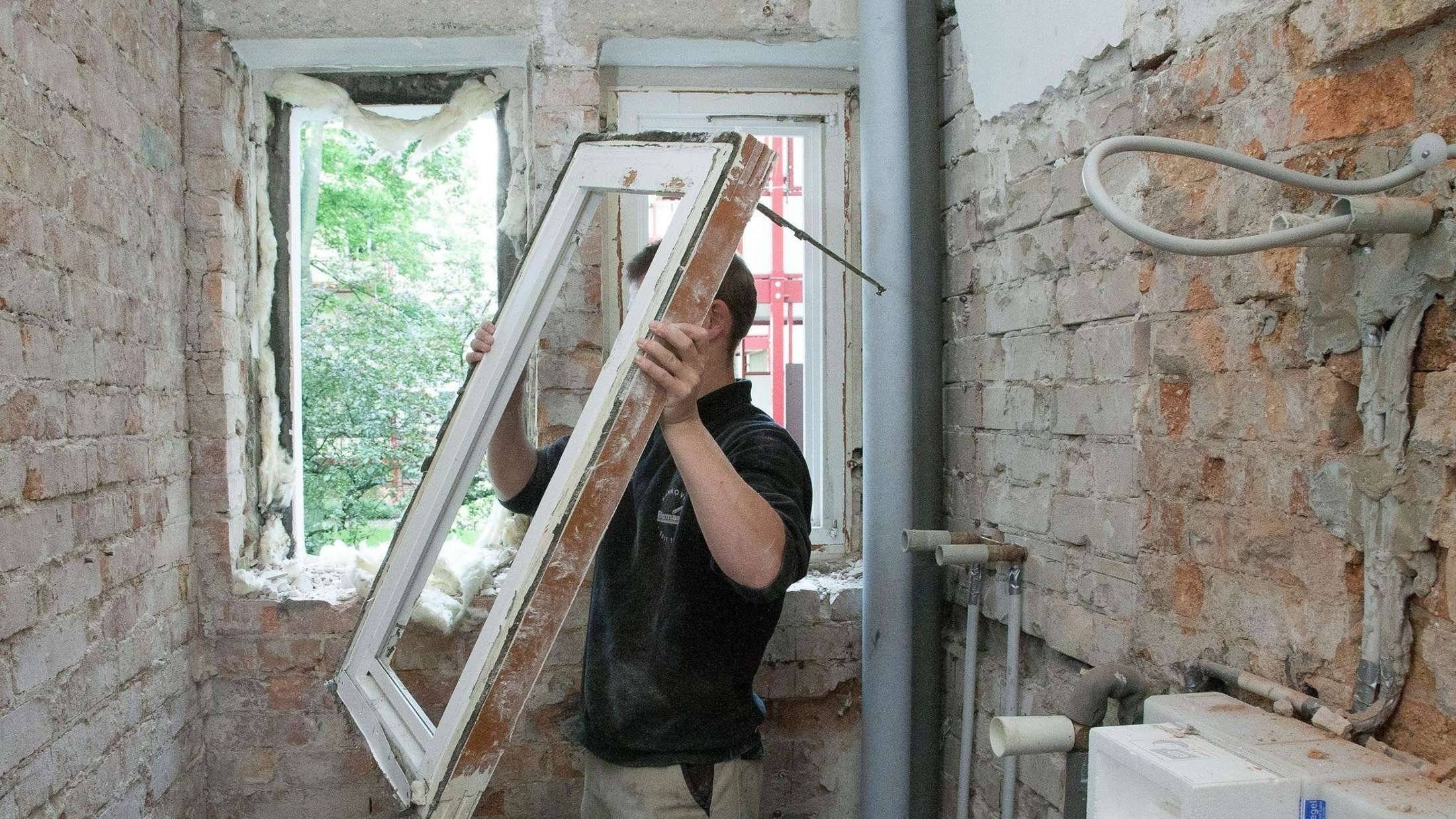 Процесс демонтажа старого окна в квартире
